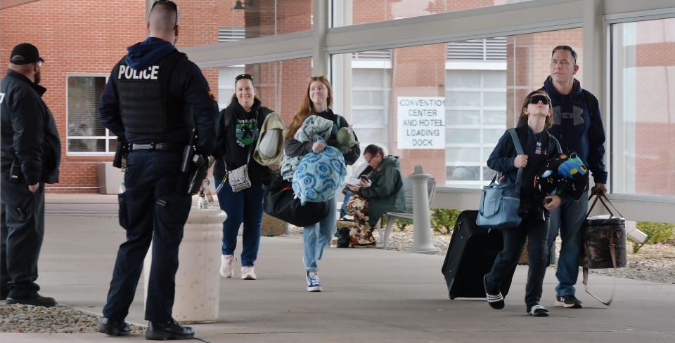 The Weaver family, from Hilltown, Pa., passes security as they leave the Courtyard Erie Bayfront Hotel in Erie on April 8, 2024. In town to view the solar eclipse, the Weavers were heading to Lake Erie Speedway in hopes of seeing the event. From back left to right, are Devon Weaver, 43; Lily Weaver, 14; Landon Weaver, 10; and Robert Weaver, 46. Devon Weaver said the family booked rooms one year ago for the trip.