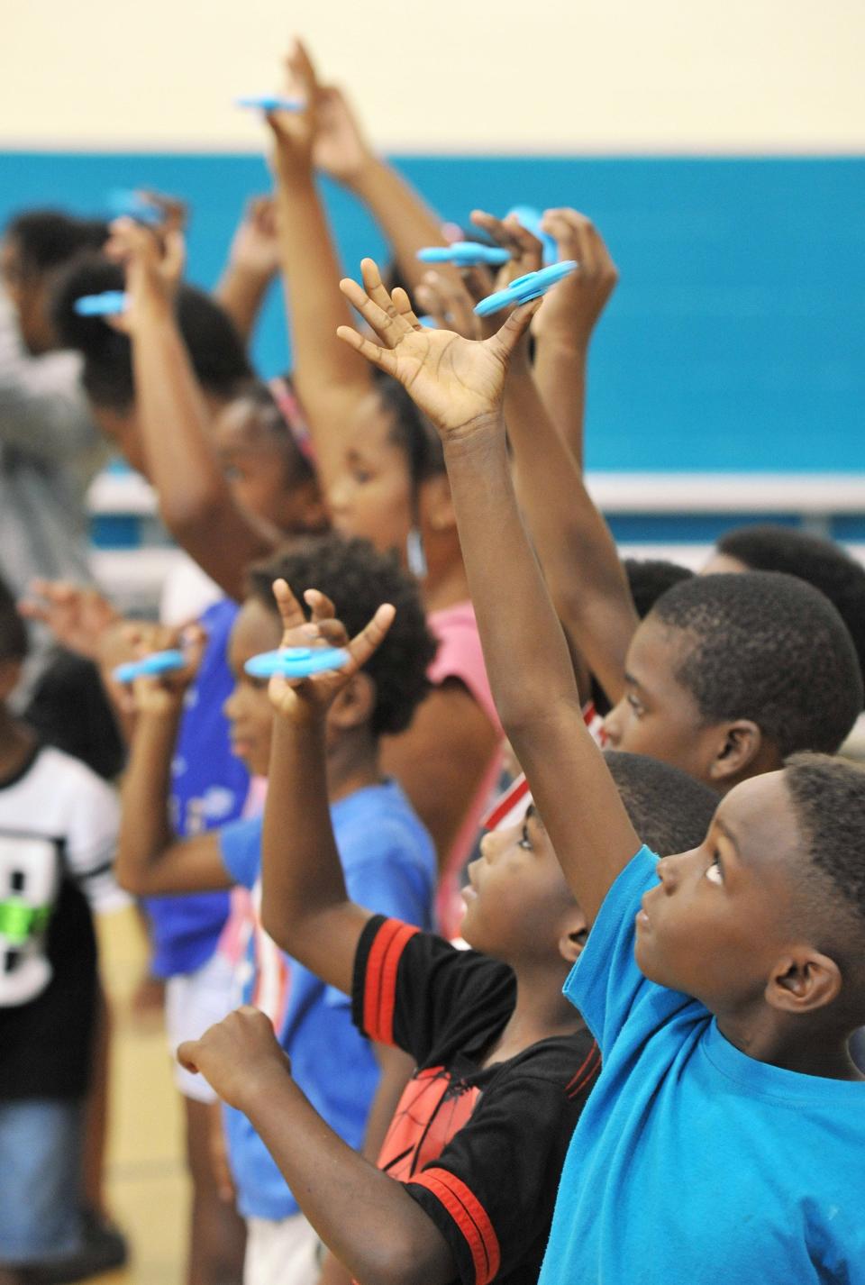 Children taking part in a Fidget Spinner day at the Boys & Girls Club of Northeast Florida hold their spinners aloft. Such programs help keep children active and prevent weight gain.