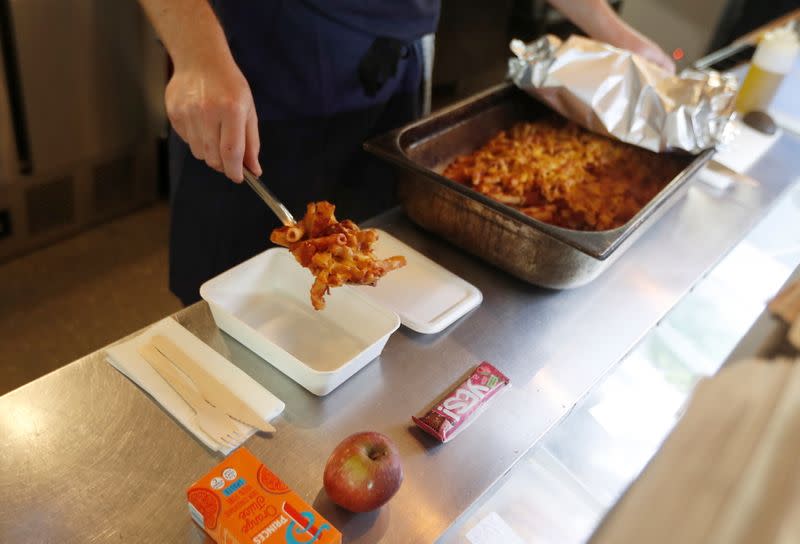 A chef from the St Giles Trust Brewbird cafe, prepares hot food packages for people in need of free school meals, in London