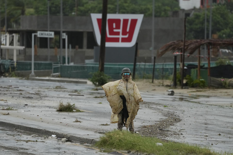 A Mexican soldier guards near a avenue flooded by the rains of Hurricane Norma in San Jose del Cabo, Mexico, Saturday, Oct. 21, 2023. Norma had weakened and was downgraded to Category 1 on the hurricane wind scale. It was located 25 miles west of Cabo San Lucas storm with winds of 85 mph (140 kmh) and expected to make landfall on Saturday, according to the U.S. (AP Photo/Fernando Llano)