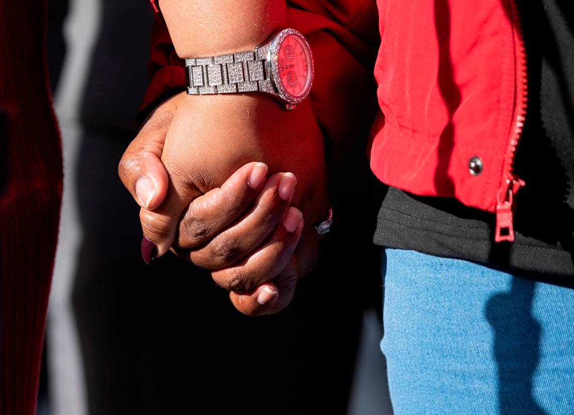 Yolanda Irving and Kenya Walton, mothers whose homes were raided in 2020 when Raleigh police officers served a no-knock warrant on the wrong home, hold hands as they speak during a press conference on Monday, Jan. 30, 2023, in Raleigh, N.C.