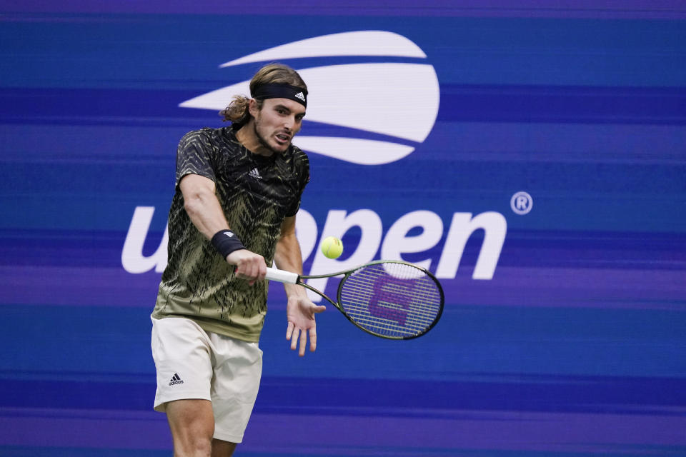 Stefanos Tsitsipas, of Greece, returns a shot to Carlos Alcaraz, of Spain, during the third round of the US Open tennis championships, Friday, Sept. 3, 2021, in New York. (AP Photo/Seth Wenig)