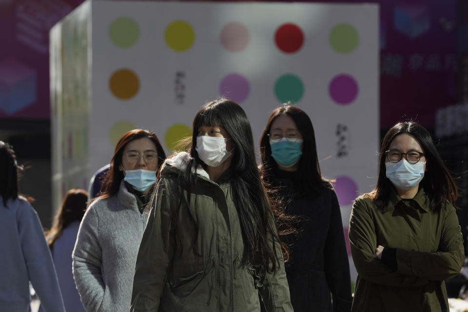 Residents wear masks as they cross the road in Beijing on Tuesday, Nov. 3, 2020. The majority of the people in the Chinese capital are still wearing masks in outdoor areas even as China has largely controlled the outbreak, while the coronavirus is still surging across the globe with an ever-rising death toll. (AP Photo/Ng Han Guan)