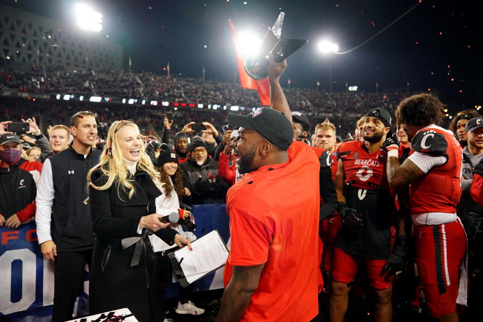 Cincinnati Bearcats running back Jerome Ford (24) raises the MVP trophy of the American Athletic Conference championship football game, Saturday, Dec. 4, 2021, at Nippert Stadium in Cincinnati. The Cincinnati Bearcats defeated the Houston Cougars, 35-20. 