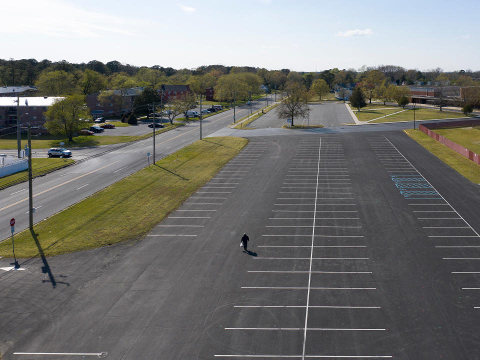 <strong>Salisbury, Md., April 11, 2020.</strong> A man walks through the parking lot of the Wicomico County Stadium. "Before the pandemic, there was no reason to notice an empty parking lot. Now, besides the supermarket and Wal-Mart, every parking lot is empty."<span class="copyright">Peter van Agtmael—Magnum Photos for TIME</span>