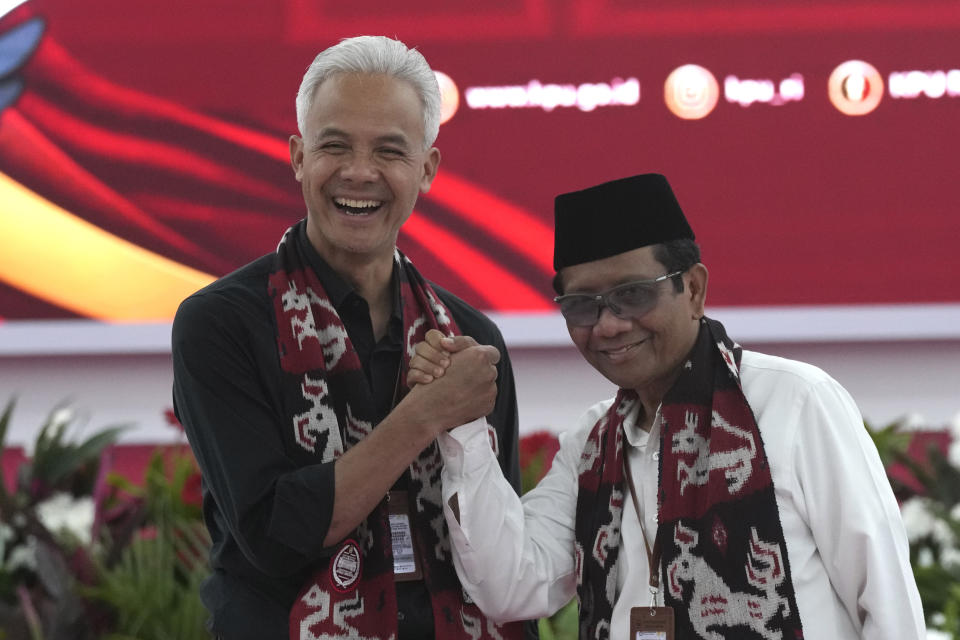 Presidential candidate Ganjar Pranowo, left, shakes hands with his running mate Mohammad Mahfud, popularly known as Mahfud MD, after officially registering their candidacy to run in the 2024 election at the General Election Commission building in Jakarta, Indonesia, Thursday, Oct. 19, 2023. The world's third-largest democracy is set to vote in simultaneously legislative and presidential elections on Feb. 14, 2024. (AP Photo/Tatan Syuflana)