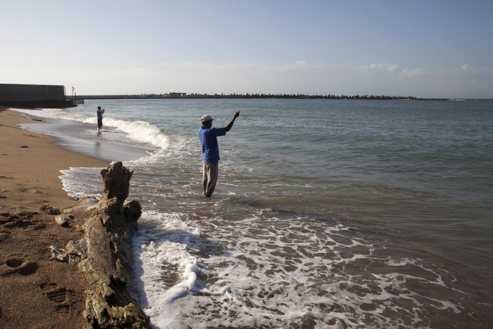 En esta imagen, tomada el 5 de abril de 2017, un hombre pesca en la playa Fray Antón de Montesinos, en Santo Domingo, República Dominicana. La colonización de América comenzó en Santo Domingo, fundada entre 1496 y 1498 por Bartolomé Colón, hermano de Cristóbal Colón. En un kilómetro cuadrado dentro de lo que fue la ciudad amurallada, aún están edificios que conservan rasgos del siglo XVI, como la primera catedral, la pierna calle adoquinada y el primer palacio del continente. (AP Foto/Tatiana Fernández)