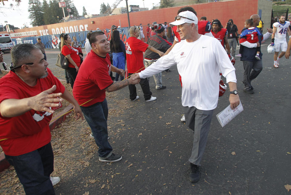 Fresno State coach Jeff Tedford gets congratulated after the game against Boise State during the second half of an NCAA college football game in Fresno, Calif., Saturday, Nov. 25, 2017. Fresno State won 28-17. (AP Photo/Gary Kazanjian)