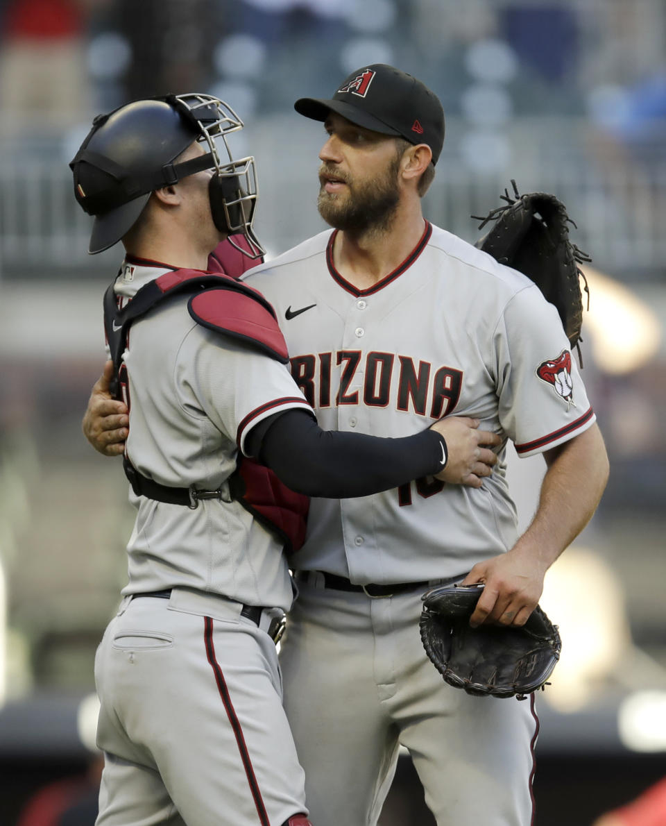 Arizona Diamondbacks pitcher Madison Bumgarner, right, is congratulated by catcher Carson Kelly after pitching a 7-inning no hitter against the Atlanta Braves, at the end of the second baseball game of a double header, Sunday, April 25, 2021, in Atlanta. (AP Photo/Ben Margot)