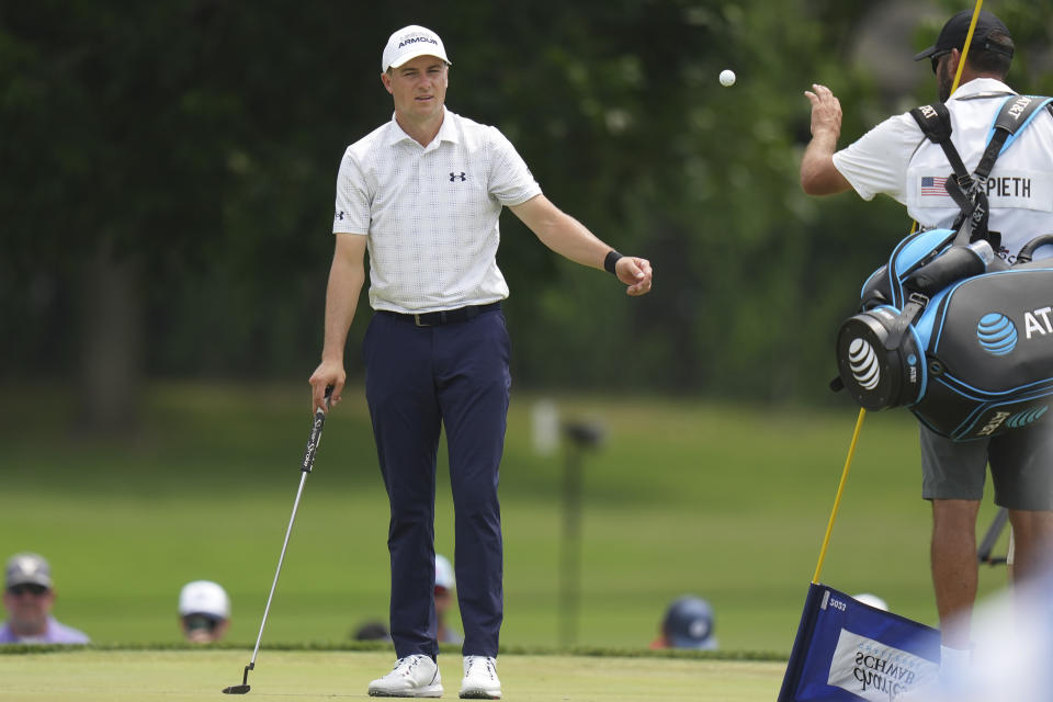 Jordan Spieth, left, tosses his ball to his caddie before putting on the sixth hole during the second round of the Charles Schwab Challenge golf tournament at Colonial Country Club in Fort Worth, Texas, Friday, May 26, 2023. (AP Photo/LM Otero)