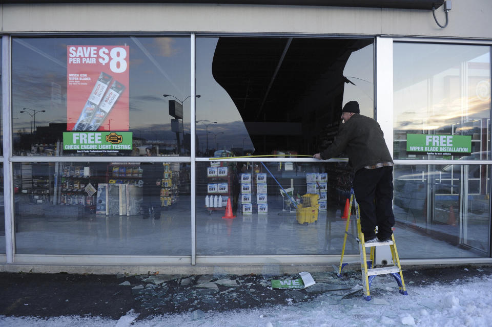 Dennis Keeling, of Instant Services, measures for a replacement window at an auto parts store following an earthquake Friday, Nov. 30, 2018, in Anchorage, Alaska. (Photo: Mike Dinneen/AP)