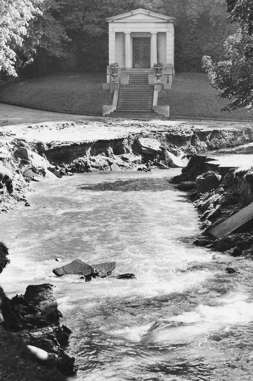 Water rushes past a mausoleum at Glendale Cemetery in June 1977 following an Akron explosion.