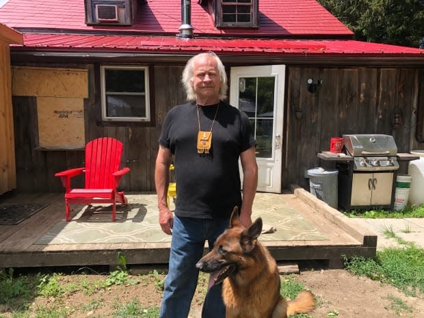 Métis elder Ralph Thistle lives in this rural cabin with no running water with his service Dog Rupert. He's owed hundreds of thousands of dollars in lost wages. (Greg Bruce/CBC News - image credit)