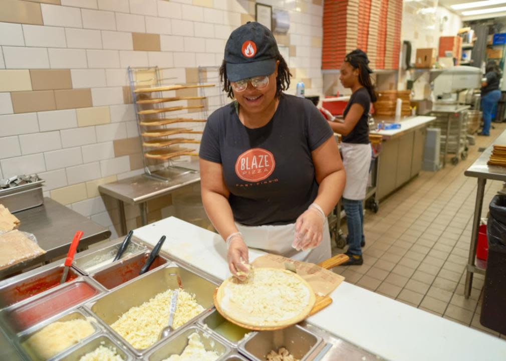 A woman making pizza at Blaze.