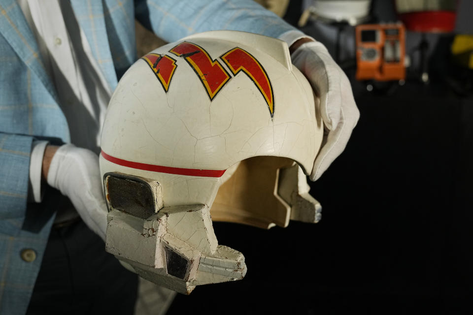 Joshua Benesh, Heritage Auction's chief strategy officer, holds a prop starfighter pilot helmet used by actor Erin Gray who played, 