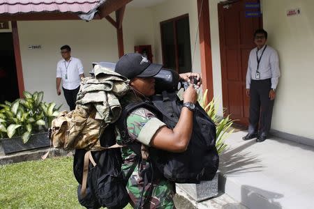 An Indonesian Navy diver prepares to load his gear onto a flight to Kalimantan in Pangkal Pinang, Bangka December 30, 2014. REUTERS/Darren Whiteside