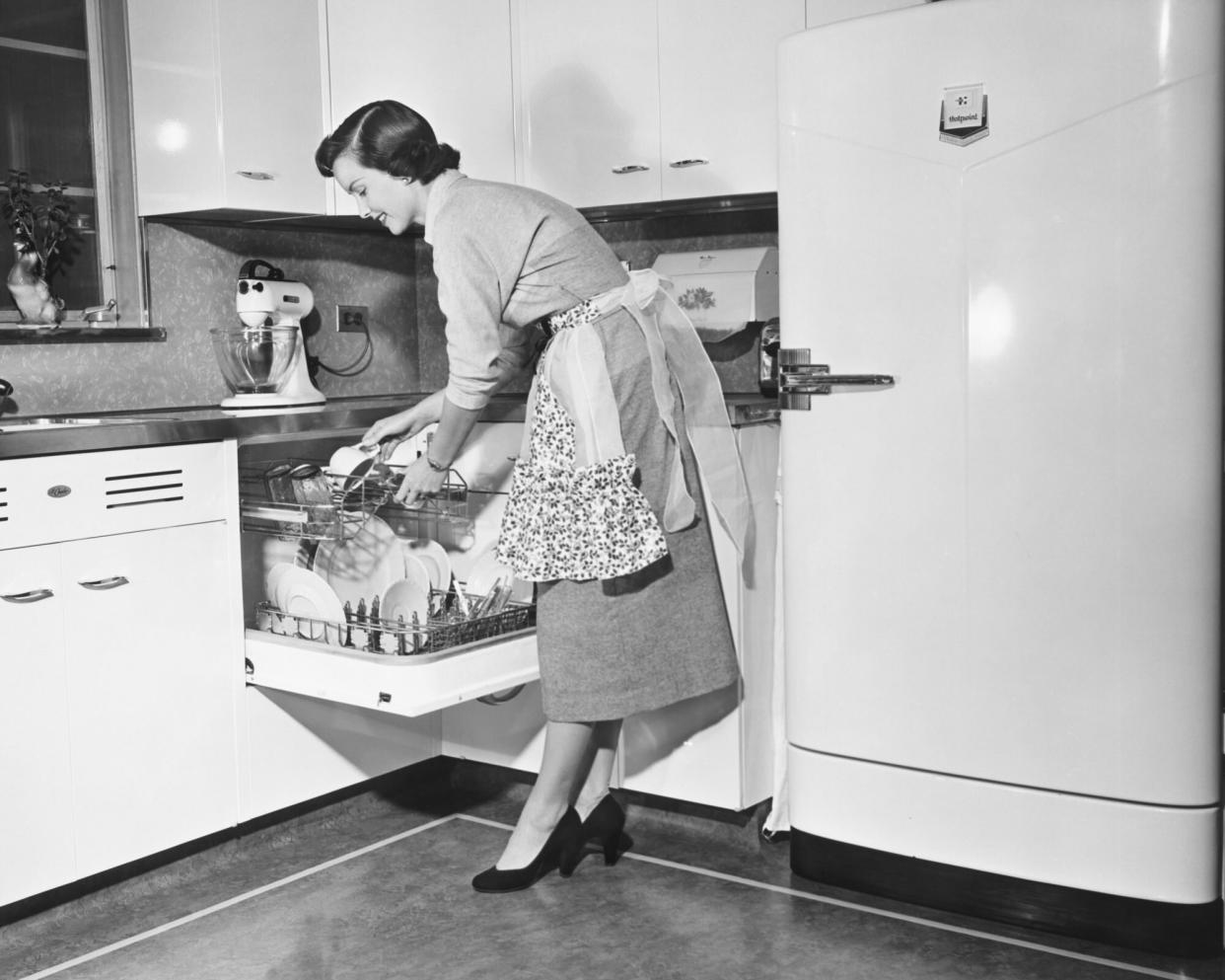 Woman loading dishwasher, (B&W)