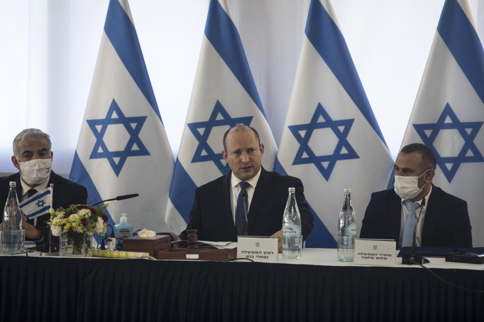Israeli Prime Minister Naftali Bennett, center, speaks at the weekly cabinet meeting in Kibbutz Mevo Hama, in the Israeli-occupied Golan Heights, Sunday, Dec. 26, 2021. Bennett said Sunday the country intends to double the amount of settlers living in the Israeli-controlled Golan Heights with a multimillion-dollar plan meant to further consolidate Israel’s hold on the territory it captured from Syria more than five decades ago. (Nir Elias/Pool via AP)