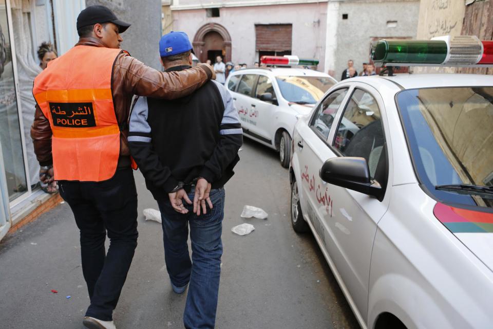 This Saturday, April 26, 2014 file photo shows a Moroccan police officer escorting a suspected drug dealer after his arrest at Derb El Kabir, a fief of crime and drugs in Casablanca, Morocco. As home to most of Morocco’s economy, as well as most its slums, Casablanca in particular has always had a crime problem. It is a city of extremes, with skyscrapers and highend nightlife on one hand and the other the crushing poverty that spawned the angry youth who killed 33 people in a spate of bombings in 2003.(AP Photo / Abdeljalil Bounhar)