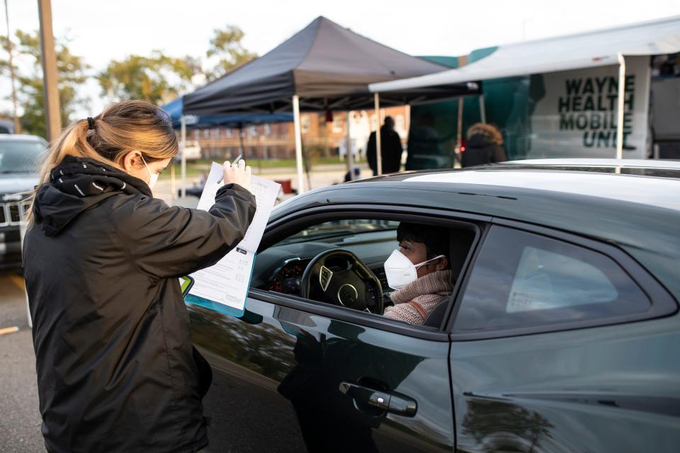 Andrea Sandoval, Wayne Health's certified nursing assistant and patient service representative talks to April Rogers of Redford before Rogers' Covid-19 booster shot outside of Third New Hope Baptist Church in Detroit on Thursday, Nov. 4, 2021.