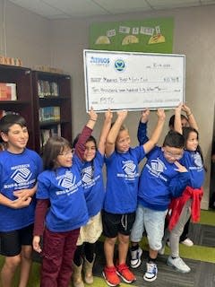 Maverick Boys and Girls Club of Amarillo Shining Stars hold the check representing the $10,750 donation from Atmos Energy, presented to the organization Thursday afternoon at the club's location, 1923 S Lincoln St.