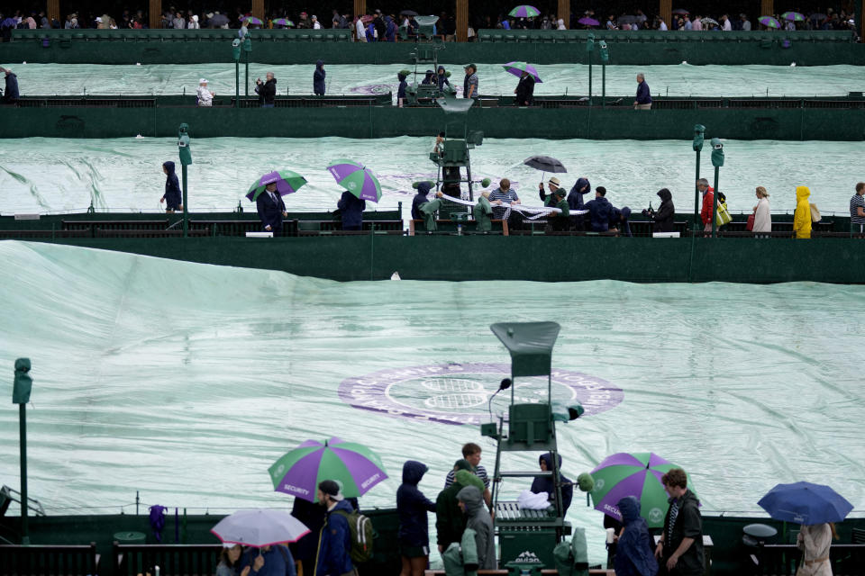 Rain covers are placed on the courts on day one of the Wimbledon tennis championships in London, Monday, June 27, 2022. (AP Photo/Alastair Grant)