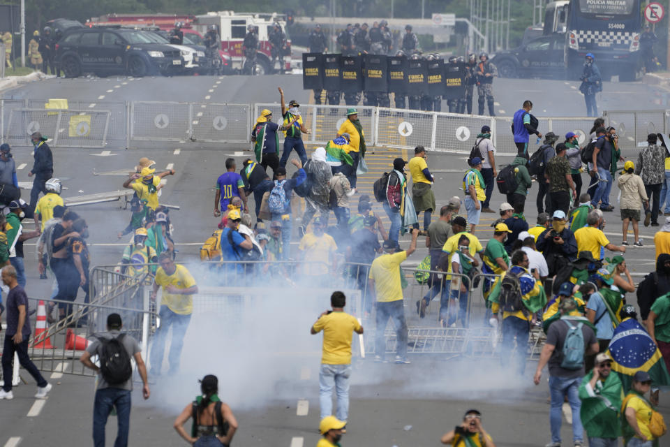 Protesters, supporters of former President Jair Bolsonaro, clash with police during a protest outside the Planalto Palace building in Brasilia, Brazil, Sunday, Jan. 8, 2023. Other demonstrators stormed congress and the Supreme Court. (AP Photo/Eraldo Peres)