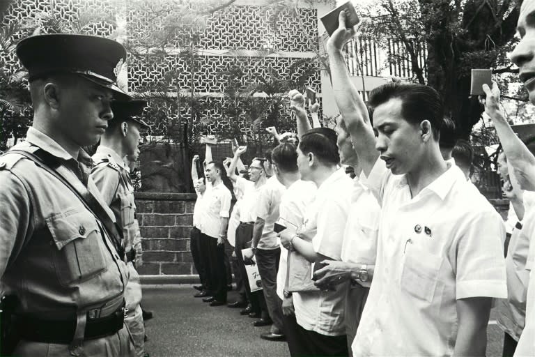 In this South China Morning Post (SCMP) archive photo taken on May 16, 1967, protesters wave their Little Red Books, 'The Quotations from Chairman Mao Zedong', in front of police outside the South Kowloon Magistracy in Hong Kong