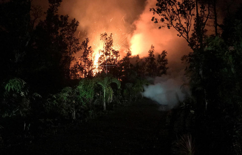 A fissure in Leilani Estates&nbsp;lights up its surroundings on Friday.