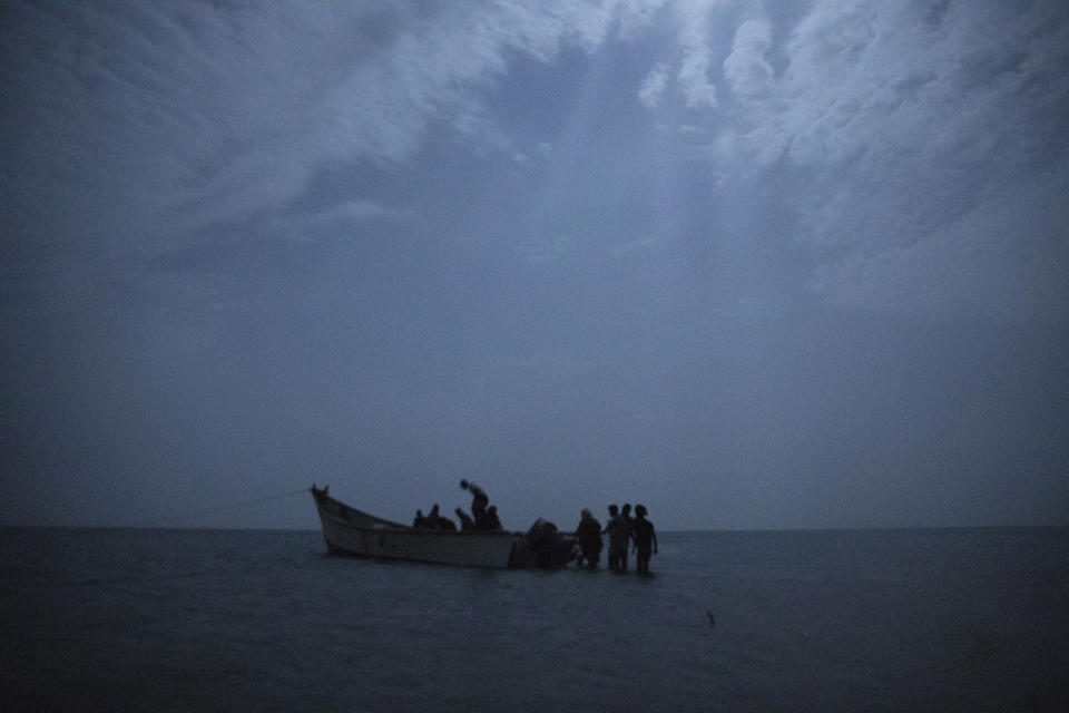 In this July 15, 2019 photo, Ethiopian migrants board a boat on the uninhabited coast outside the town of Obock, Djibouti, the shore closest to Yemen. Tens of thousands of East African migrants depart for Yemen each year hoping to pass through to Saudi Arabia, where good jobs await. But many who land in the Yemeni town of Ras Al-Ara encounter extortion, rape and torture. (AP Photo/Nariman El-Mofty)
