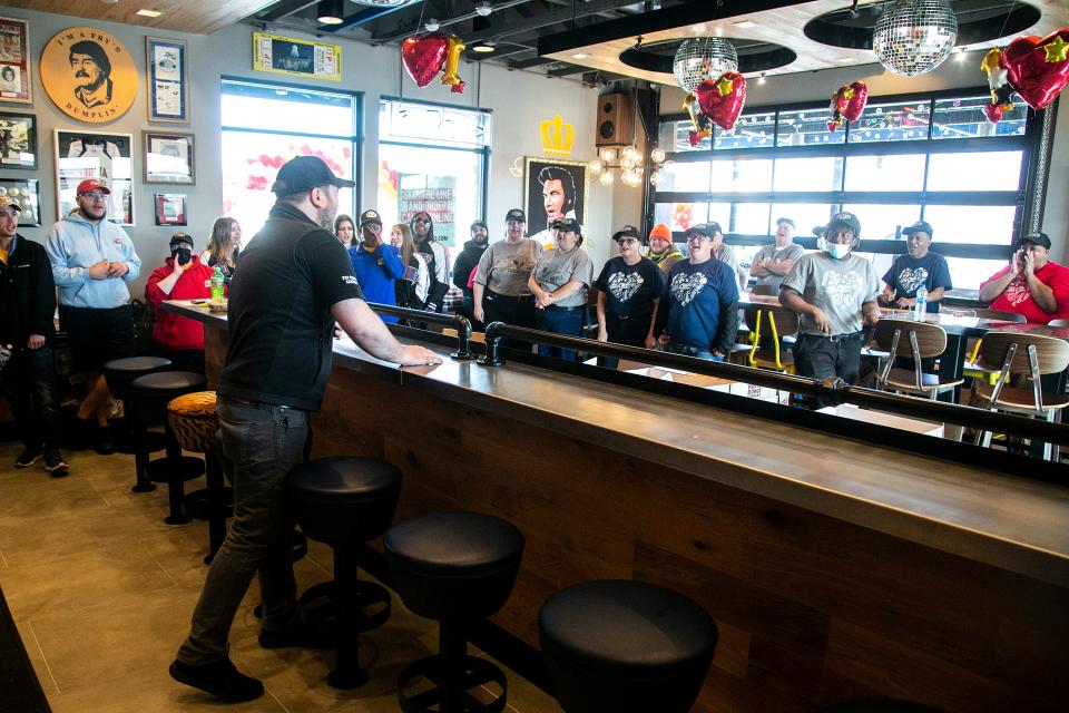 Raising Cane's Chicken Fingers employees do a chant during the grand opening for the restaurant Tuesday at 2800 Commerce Drive in Coralville.