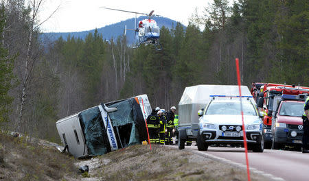 Rescue workers are seen at the site where a bus carrying school children and adults rolled over on a road close to the town of Sveg, in northern Sweden April 2, 2017. TT News Agency/Nisse Schmidt/via REUTERS