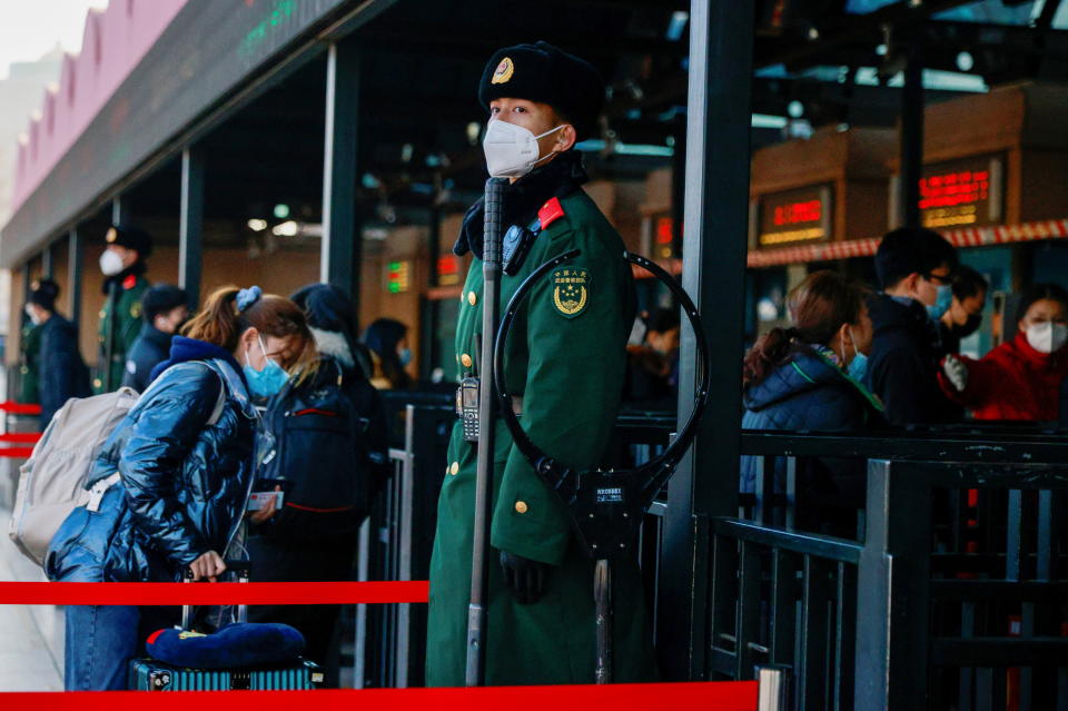 因應新冠肺炎疫情，北京政府敦促民眾避免旅行，並安排警察在火車站加強防疫管制。圖片來源：Reuters。