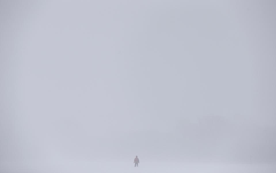 A pedestrian walks on the Plains of Abraham during a snowstorm in Quebec City