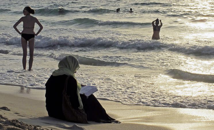 woman cover from head to toe on a beach