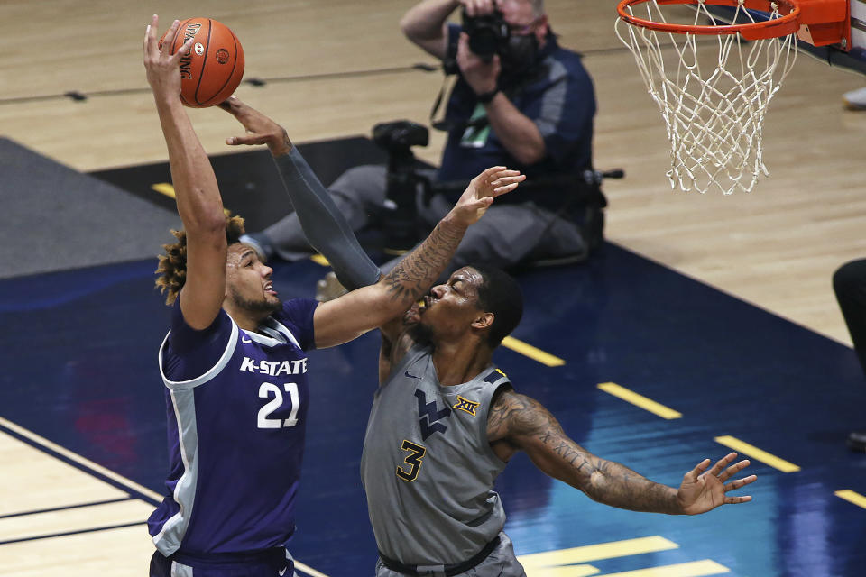 West Virginia forward Gabe Osabuohien (3) is defended by Kansas State forward Davion Bradford (21) during the first half of an NCAA college basketball game Saturday, Feb. 27, 2021, in Morgantown, W.Va. (AP Photo/Kathleen Batten)