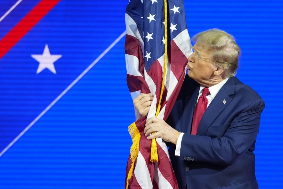 Former President Donald Trump pauses to kiss the flag during his Feb. 24 speech at CPAC, in Maryland.