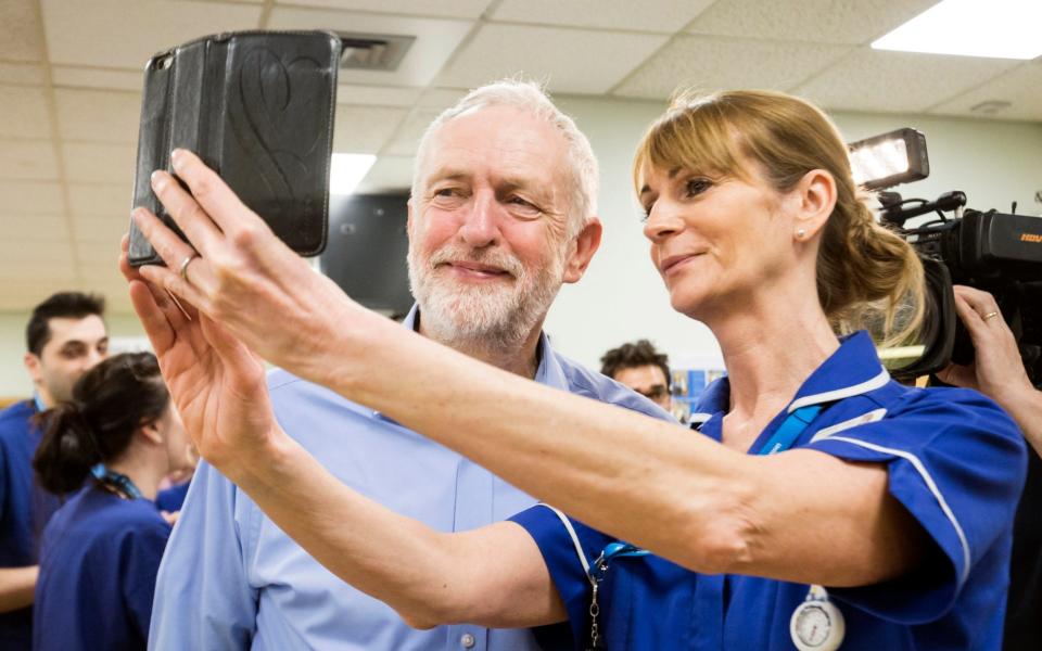 Jeremy Corbyn, the Labour leader poses for a selfie with a member of staff during a visit to Lincoln County Hospital - PA