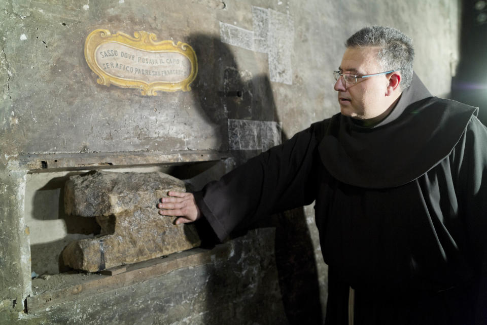 The head of the Franciscan convent of St. Francesco a Ripa, Friar Stefano Tamburo touches a stone believed to be used by St. Francis of Assisi as a pillow when visiting the convent in Rome, Friday, Feb. 28, 2014. The inscription reads in Italian: "Stone where the Serafic Father St. Francis would rest his head". The friars who run the St. Francis a Ripa church in Rome's Trastevere neighborhood are launching a Kickstarter online fundraising campaign Tuesday, March 11, 2014, to try to raise the $125,000 to restore the tiny cell upstairs from the sacristy where St. Francis stayed, The Associated Press has learned. Rather than ask for funding from the Italian government, which owns the church and is responsible for its upkeep, the friars decided on this more democratic crowdfunding initiative thinking it more in keeping with the Franciscan tradition of seeking alms for just what they need, spreading the faith as they beg, and making sure the poor are the priority. (AP Photo/Domenico Stinellis)