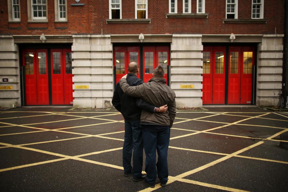 Christian McClean and colleague Ricky Cooper comfort each other after they finished the last ever shift at Clerkenwell fire station in January 2014 (Peter Macdiarmid/Getty Images)