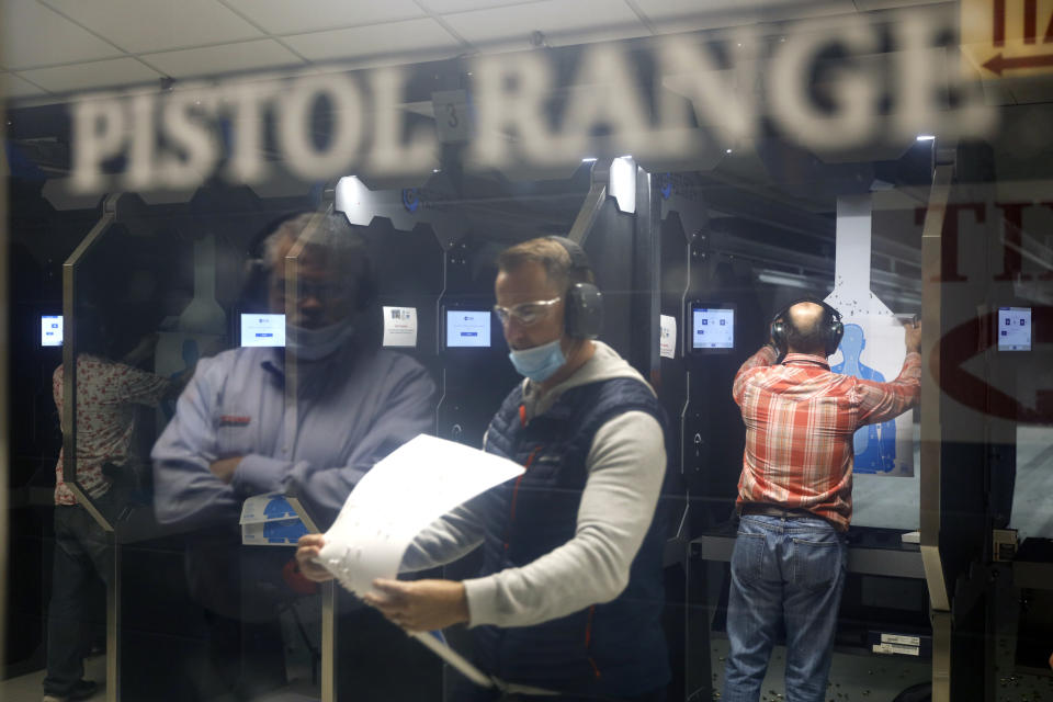 Maxon Shooter's Supplies and Indoor Range owner Dan Eldridge is reflected on a glass door as he watches the shooters at the pistol range, Friday, April 30, 2021, in Des Plaines, Ill. After a year of pandemic lockdowns, mass shootings are back, but the guns never went away. As the U.S. inches toward a post-pandemic future, guns are arguably more present in the American psyche and more deeply embedded in American discourse than ever before. The past year's anxiety and loss fueled a rise in gun ownership across political and socio-economic lines. (AP Photo/Shafkat Anowar)