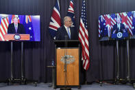 Australia's Prime Minister Scott Morrison, center, appears on stage with video links to Britain's Prime Minister Boris Johnson, left, and U.S. President Joe Biden at a joint press conference at Parliament House in Canberra, Thursday, Sept. 16, 2021. The leaders are announcing a security alliance that will allow for greater sharing of defense capabilities — including helping equip Australia with nuclear-powered submarines. (Mick Tsikas/AAP Image via AP)