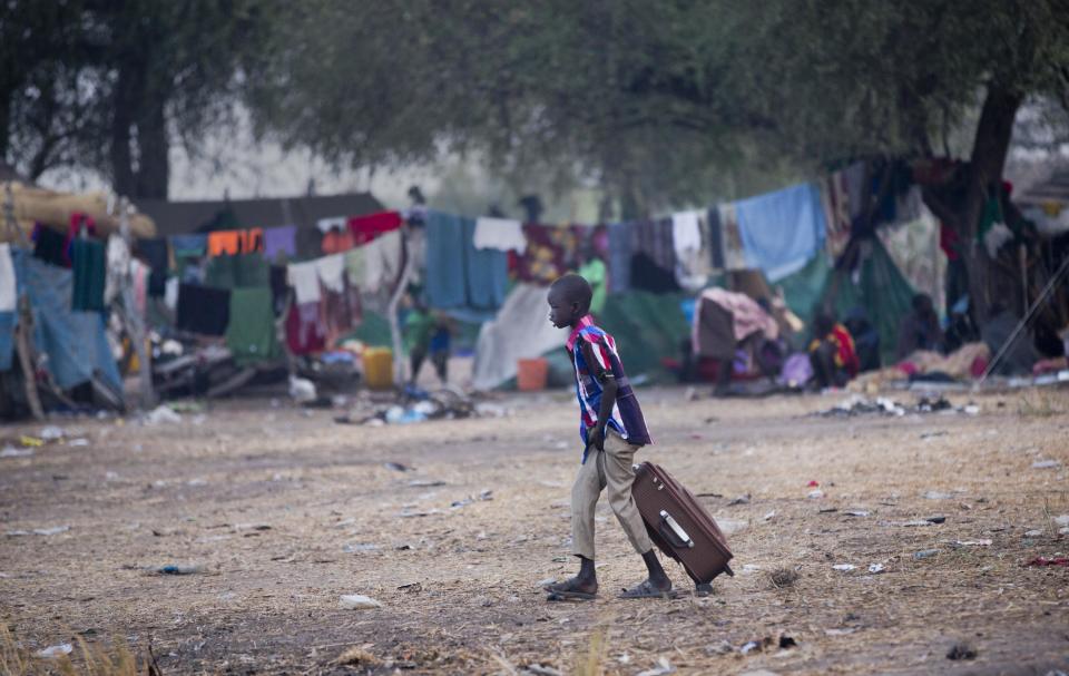 A young displaced boy pulls his suitcase of belongings as he walks to find a place to rest after getting off a river barge from Bor, one of the thousands who fled the recent fighting between government and rebel forces in Bor by boat across the White Nile, in the town of Awerial, South Sudan Thursday, Jan. 2, 2014. The international Red Cross said Wednesday that the road from Bor to the nearby Awerial area "is lined with thousands of people" waiting for boats so they could cross the Nile River and that the gathering of displaced is "is the largest single identified concentration of displaced people in the country so far". (AP Photo/Ben Curtis)