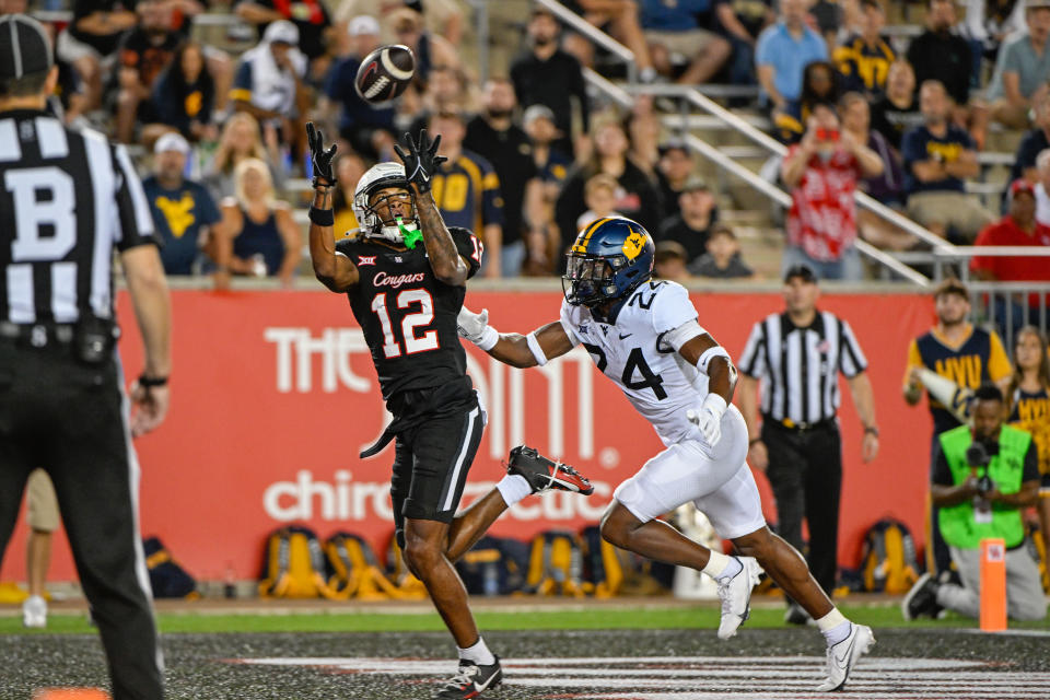 HOUSTON, TX - OCTOBER 12: Houston Cougars wide receiver Stephon Johnson (12) hauls in a late second half touchdown reception as West Virginia Mountaineers safety Marcis Floyd (24) defends during the football game between the West Virginia Mountaineers and Houston Cougars at TDECU Stadium on October 12, 2023, in Houston, Texas. (Photo by Ken Murray/Icon Sportswire via Getty Images)