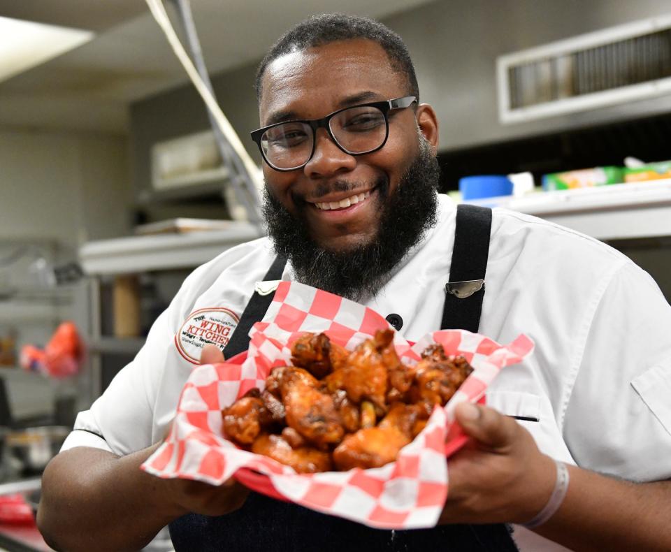 Chef Timothy Witcher holds an order of Buffalo wings. Owner of The Wing Kitchen, Witcher won the Food Network's Chopped and specializes in chicken wings and buttermilk-fried doughnuts. He has locations at Clementon Park, Lincoln Financial Field, Subaru Park and more.