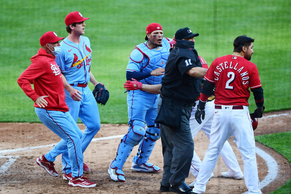 CINCINNATI, OHIO - APRIL 03: Yadier Molina #4 of the St. Louis Cardinals goes after Nick Castellanos #2 of the Cincinnati Reds after he slides safely into home base for a run in the fourth inning at Great American Ball Park on April 03, 2021 in Cincinnati, Ohio. (Photo by Emilee Chinn/Getty Images)