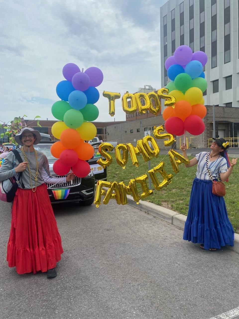 "TODOS SOMOS FAMILIA," which in English translates to "We Are All Family," is a message carried by Grupo Cultural Latinos in the 2023 Rochester Pride Parade on Saturday, July 15. At left is Phillip Guingona, and at right is Ling Ma.