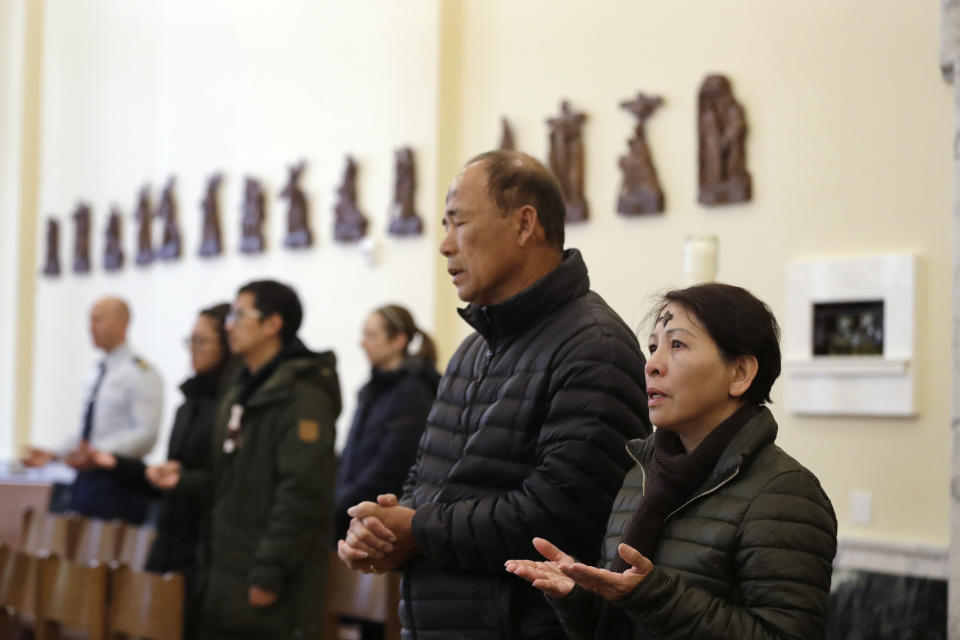 Mina Nguyen, right, and her husband Huu Tran pray with others after having the sign of the cross placed on their foreheads with ash during an Ash Wednesday service at Christ Our Hope Catholic Church, Wednesday, Feb. 26, 2020, in Seattle. Ash Wednesday marks the beginning of Lent, a solemn period of 40 days of prayer and self-denial leading up to Easter. (AP Photo/Elaine Thompson)