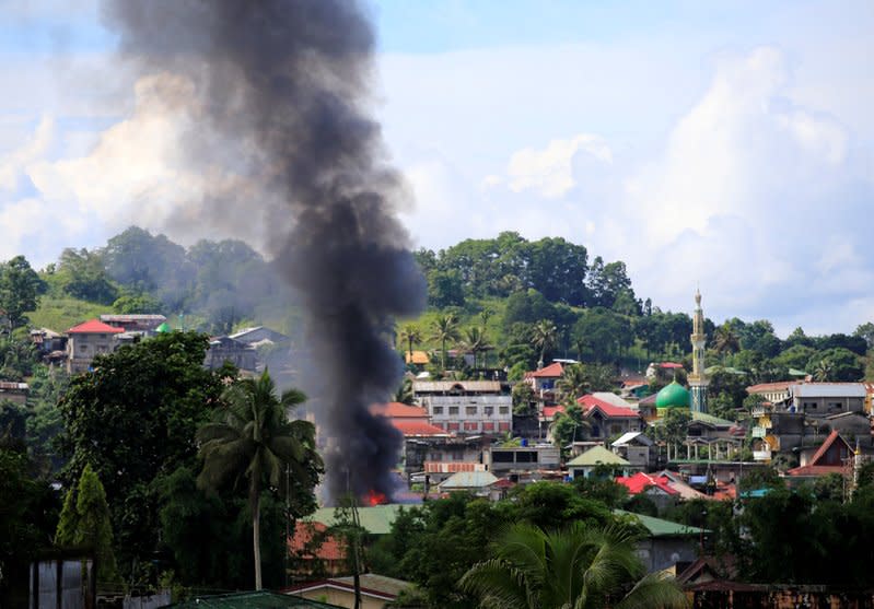 Smoke billowing from a burning building is seen as government troops continue their assault on insurgents from the Maute group, who have taken over large parts of Marawi City. REUTERS/Romeo Ranoco