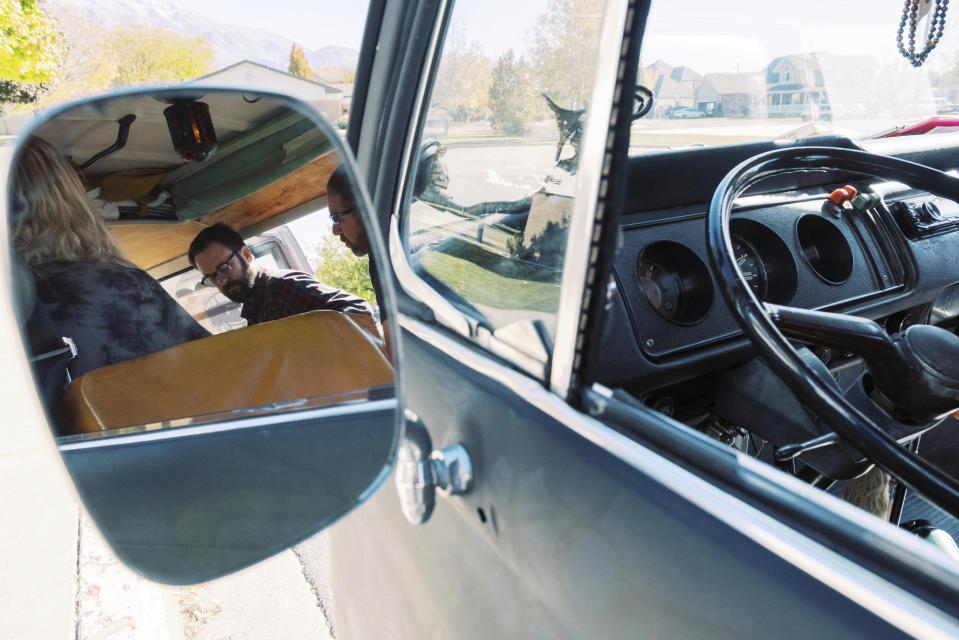 A beaded necklace hangs on the rearview mirror of the Chalkbus as Mid-Life Crisis plays out of the bus on Saturday, Oct. 26, 2019, in American Fork, Utah. (Michael Schnell/The Daily Herald via AP)